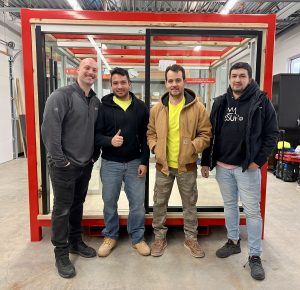 MetroWall installers standing in room with glass systems after certification training.